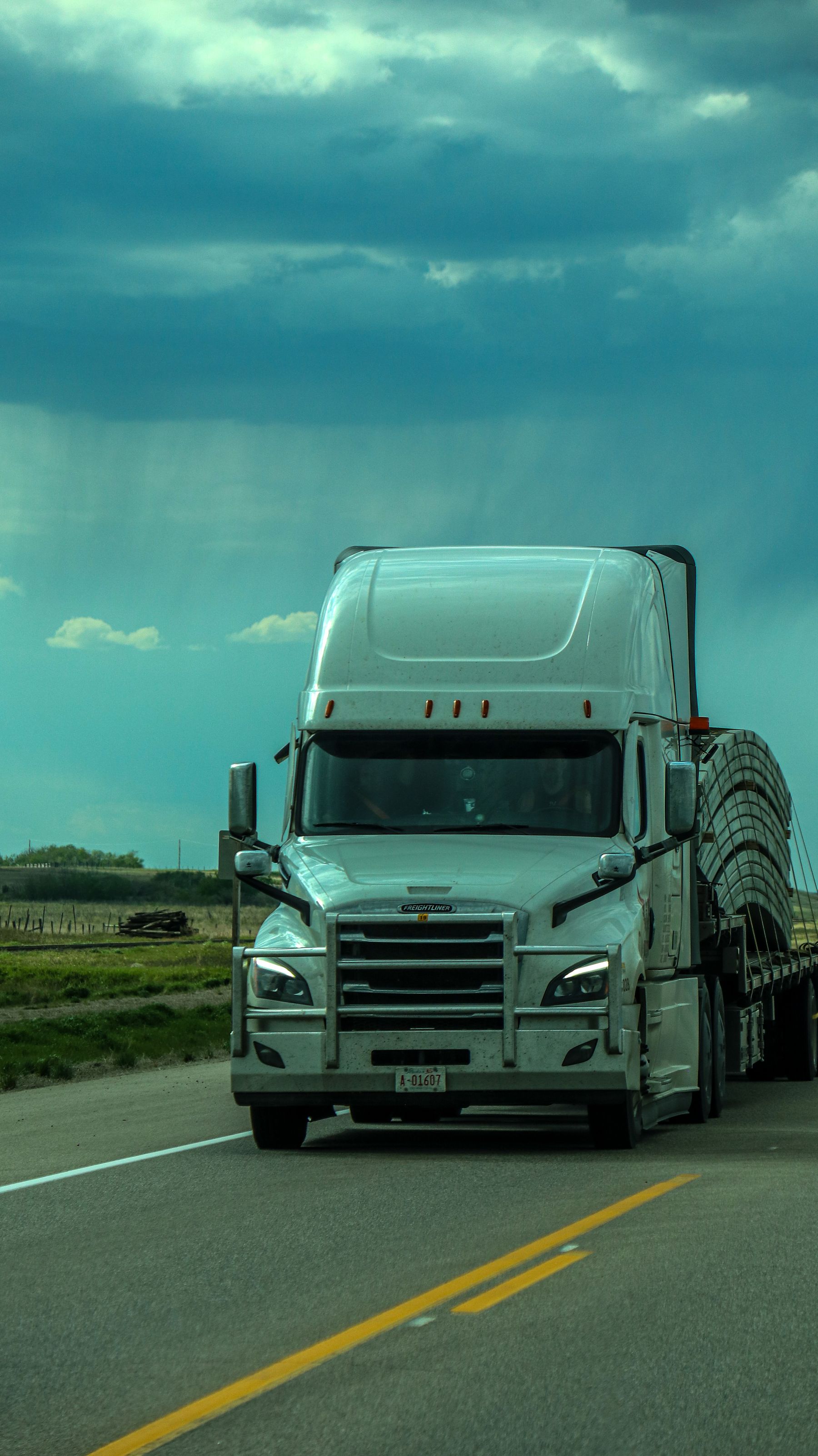 White freight truck traveling on a roadway